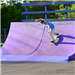 Youth riding skateboard down ramp at skate park